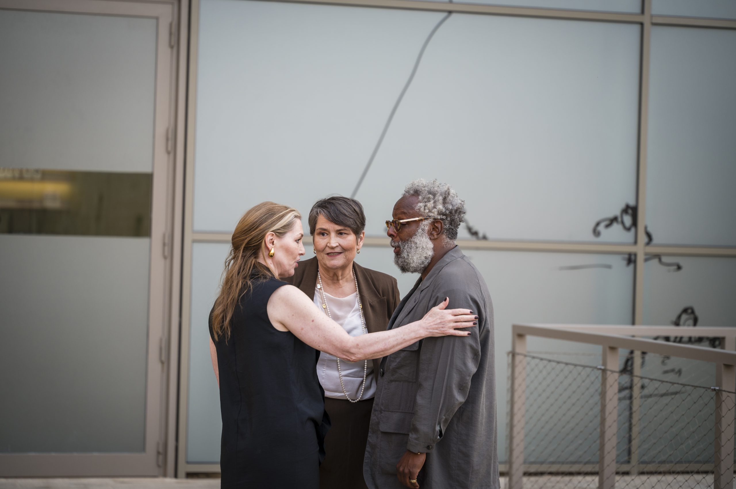 MICAS Artistic Director Edith Devaney and MICAS Chairperson Phyllis Muscat (centre) exchange a few words with Reggie Burrows Hodges ahead of the opening of Mela, May 2026. Photo: Robert Goodman